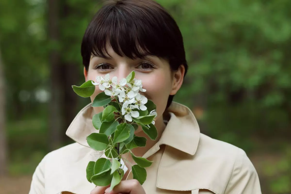 Mesaje de 8 martie- Femeie care miroase un buchet de lăcărmioare