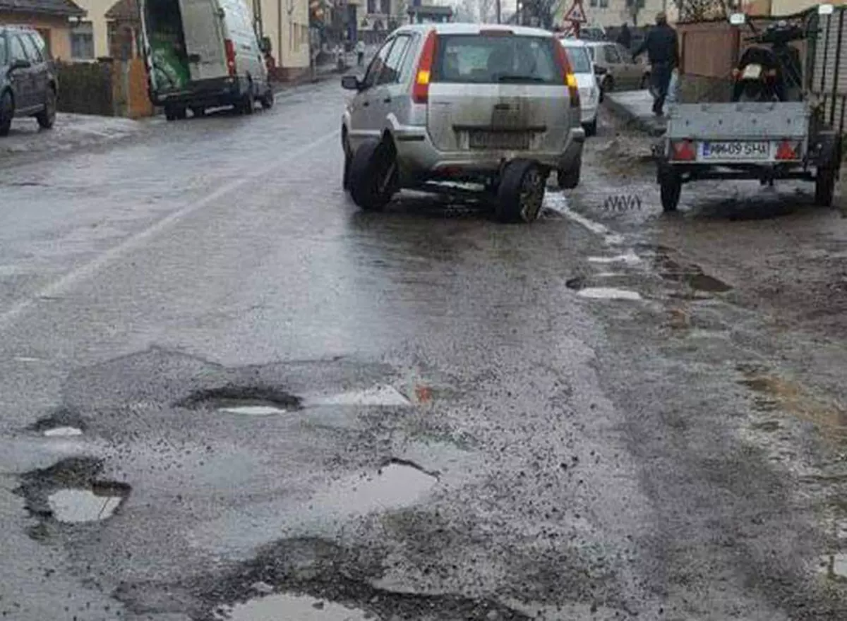 Și-a rupt maşina în două într-o groapă acoperită cu apă