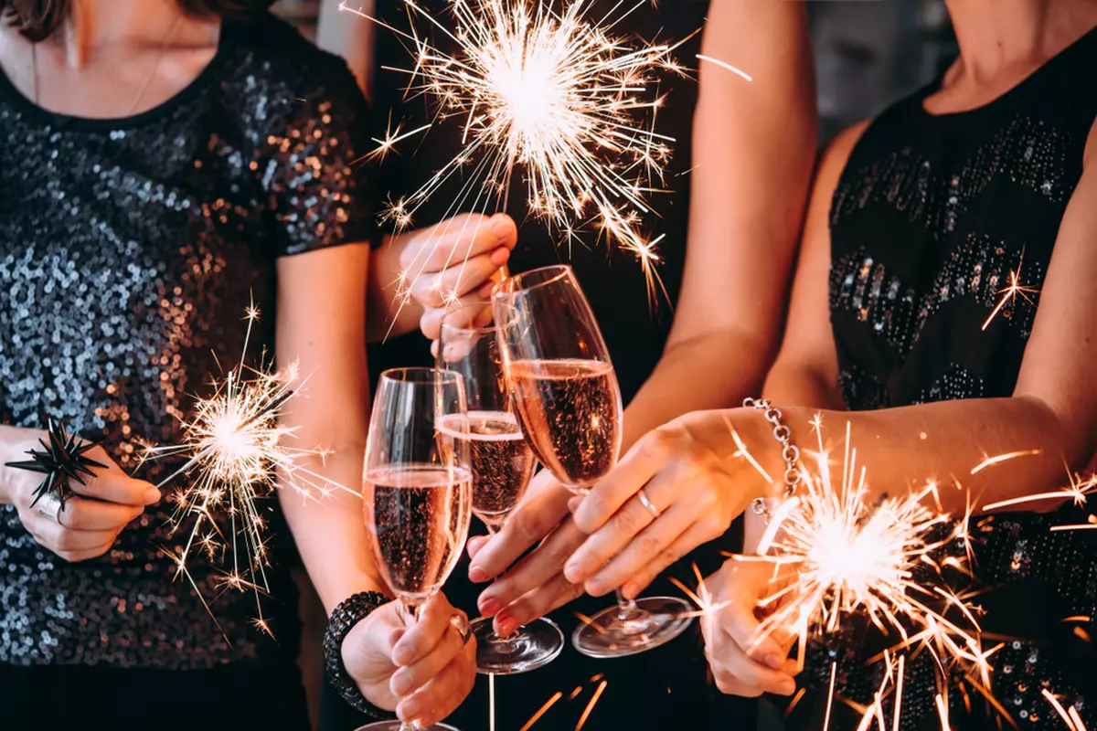 Rochițe pentru Revelion 2023 - ce rochii se poartă de Anul Nou - Imagine cu tinere care sărbătoresc Anul Nou cu artificii şi şampanie