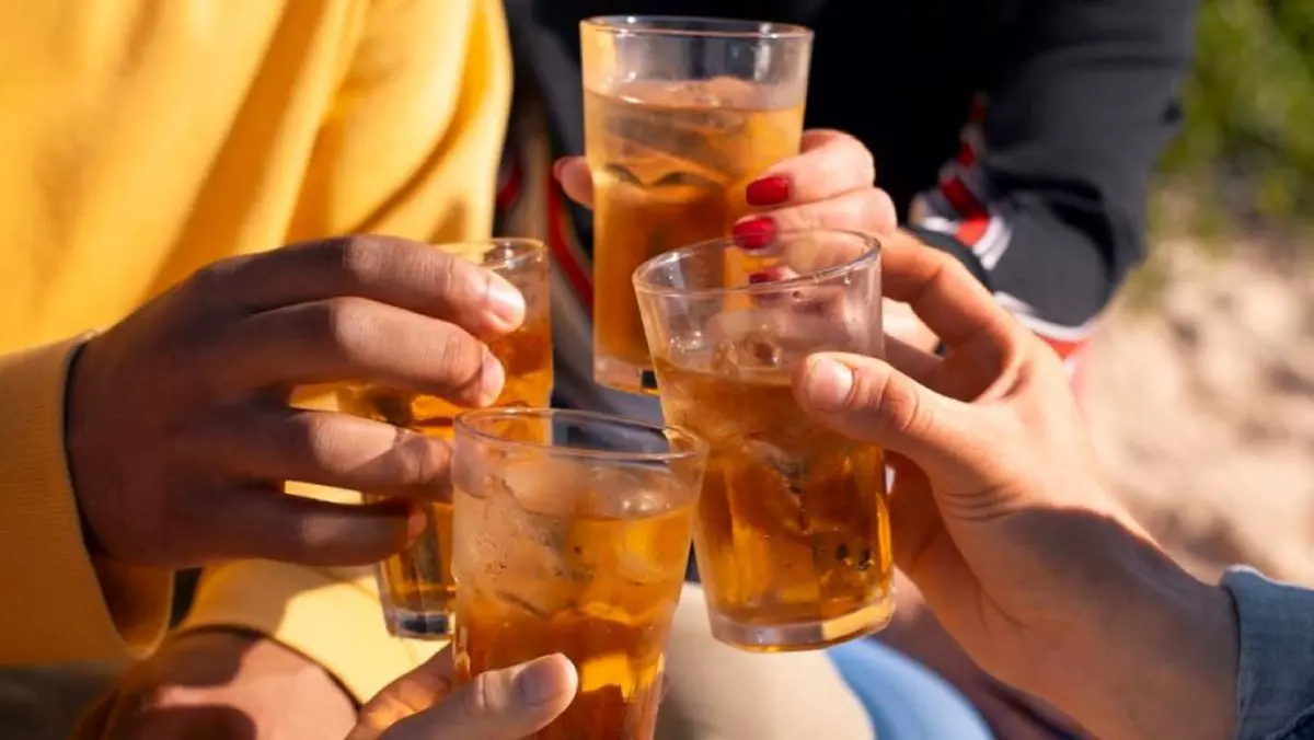 Mai mulți oameni ciocnesc savurează câte un pahar cu alcool