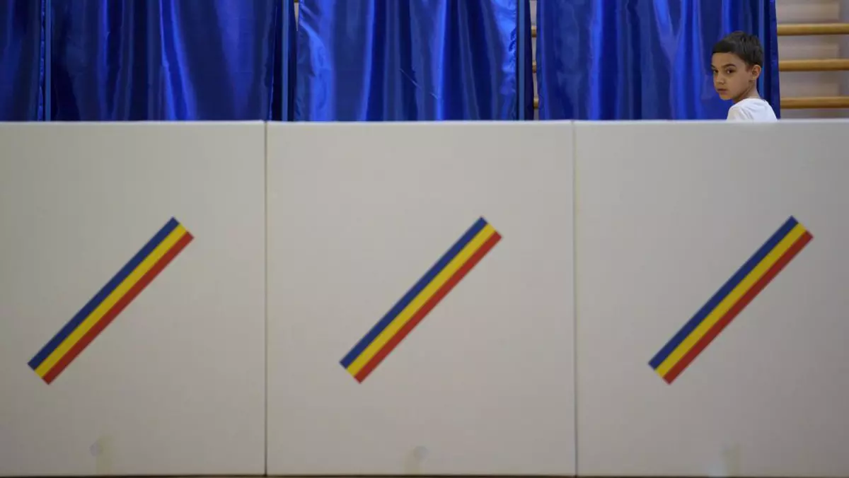 Un copil privește urnele de vot într-o secție de votare din București. Imagine realizată la 9 iunie 2024.