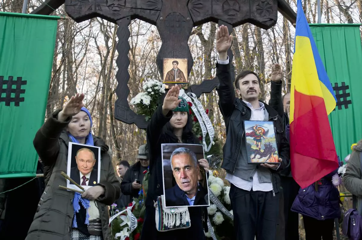 Susținătorii Partidului Naționalist pentru Țară de dreapta salută și afișează fotografii cu Corneliu Zelea Codreanu, în Tancăbești, România, Hepta