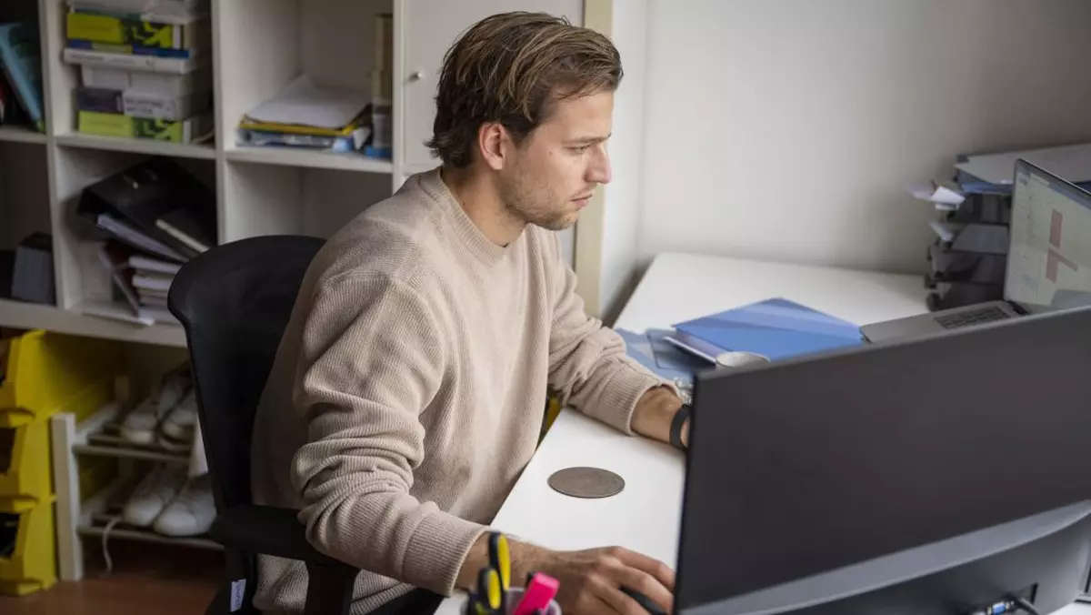 Bărbat surprins în timp ce lucrează la laptop