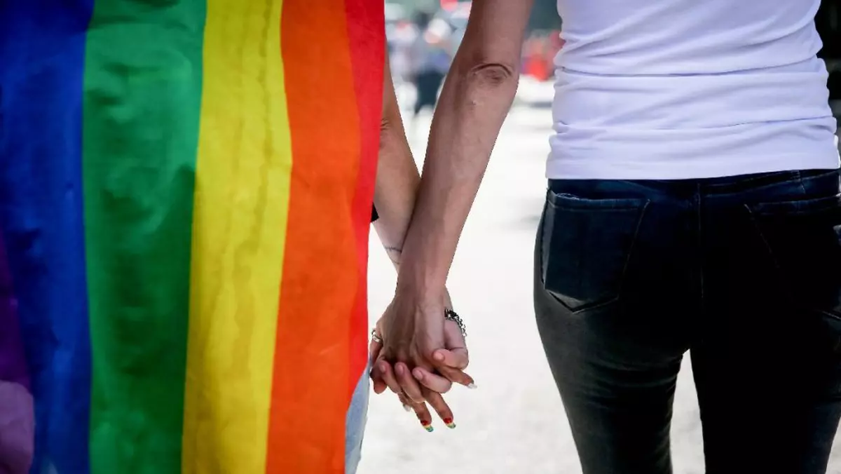 Un cuplu merge de mână în timpul Paradei Argentina Pride 2023, în Buenos Aires. Parada Pride LGBT