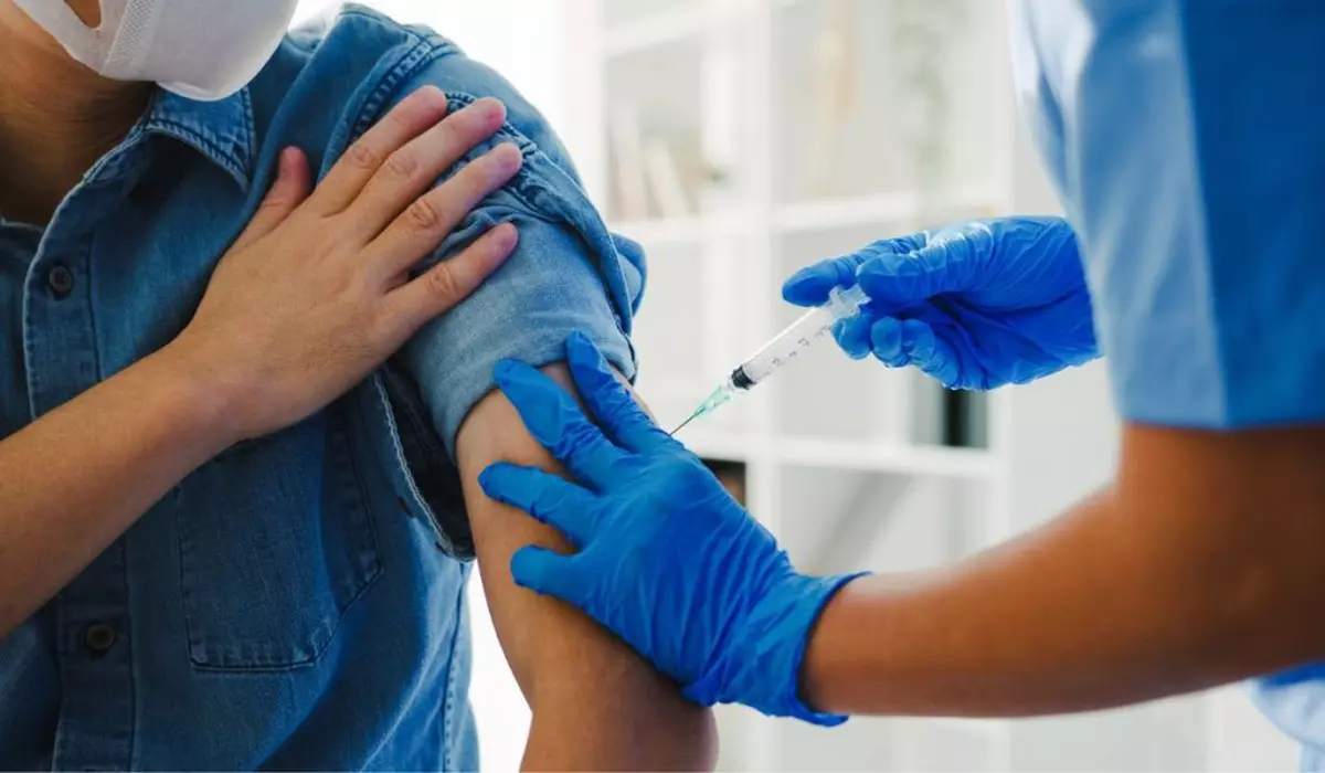 o asistentă medicală administrează un vaccin unui pacient