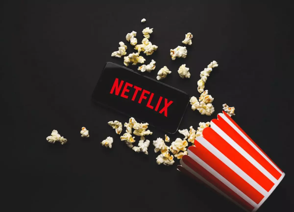 Filme și seriale noi pe Netflix în martie 2025 - logo Netflix, cutie cu popcorn
