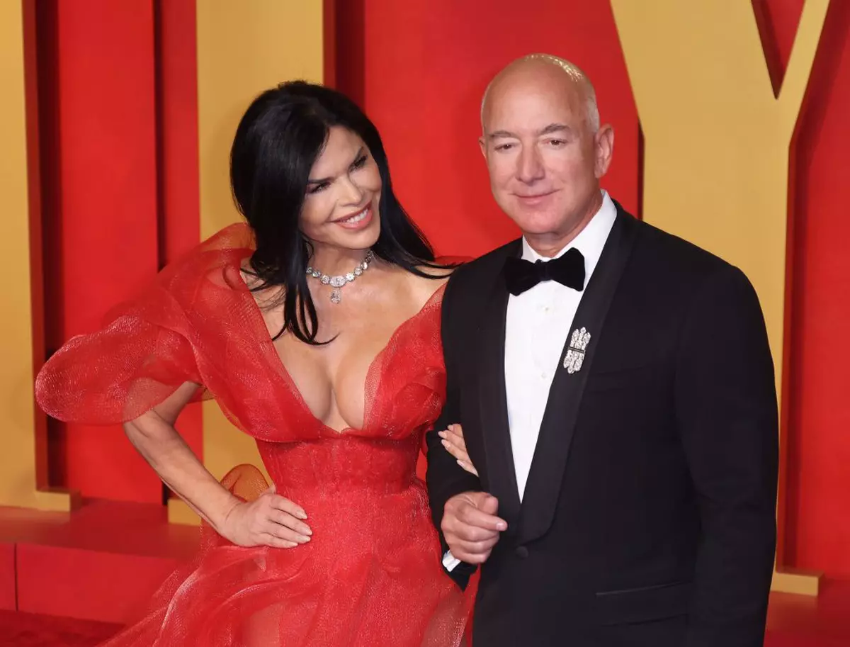 Lauren Sánchez, într-o rochie roșie decoltată, alături de miliardarul Jeff Bezos participă la Vanity Fair Oscar Party 2024 . FOTO: Hepta