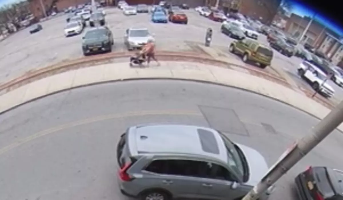 Imaginea este surprinsă de camera de supraveghere. Aceasta ilustrează o femeie pe stradă și mașini