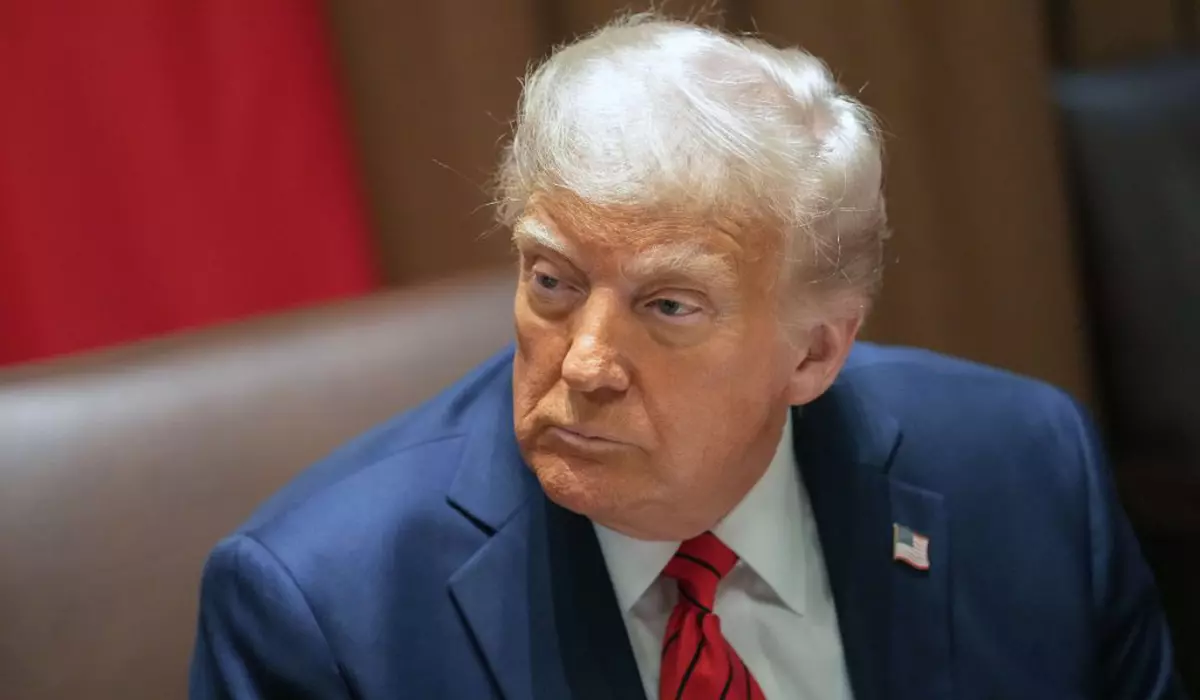 În imagine este ilustrat Donald Trump, îmbrăcat în costum albastru închis, cămașă albă și cravată roșie