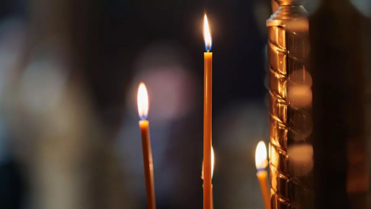 lumânări aprinse în templu, lumânări de ceară aprinse pe fundalul unei cruci cu un crucifix, conceptul religiei creștine, rugăciuni