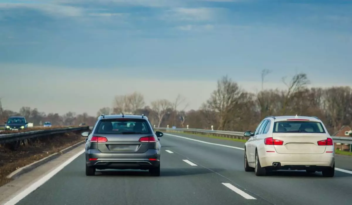 Două mașini aflate pe o autostradă cu două benzi pe sens.