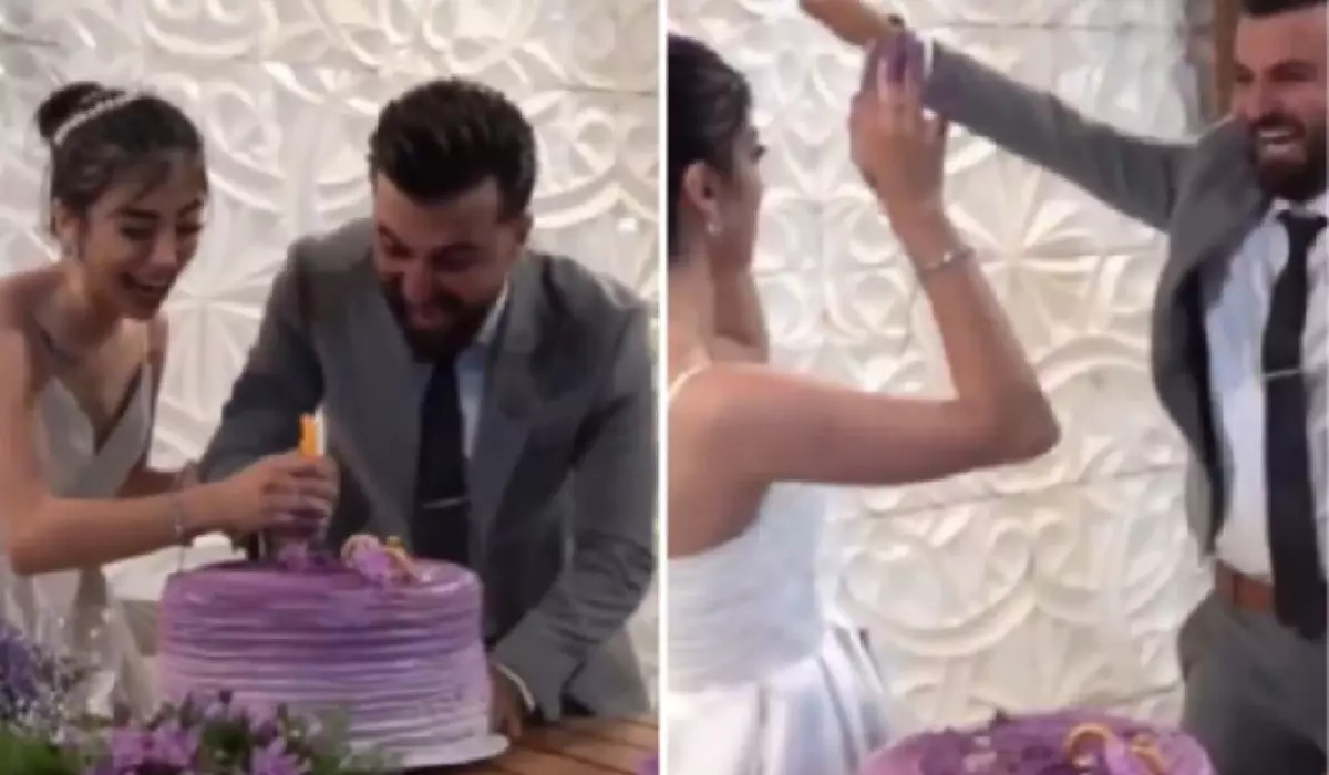 Mireasa poartă o rochie albă, fără bretele,mirele este îmbrăcat într-un costum gri, cămașă albă și cravată închisă la culoare.Cei doi se află în fața unui tort de nuntă mare, rotund, decorat în nuanțe de mov și lila, cu detalii florale