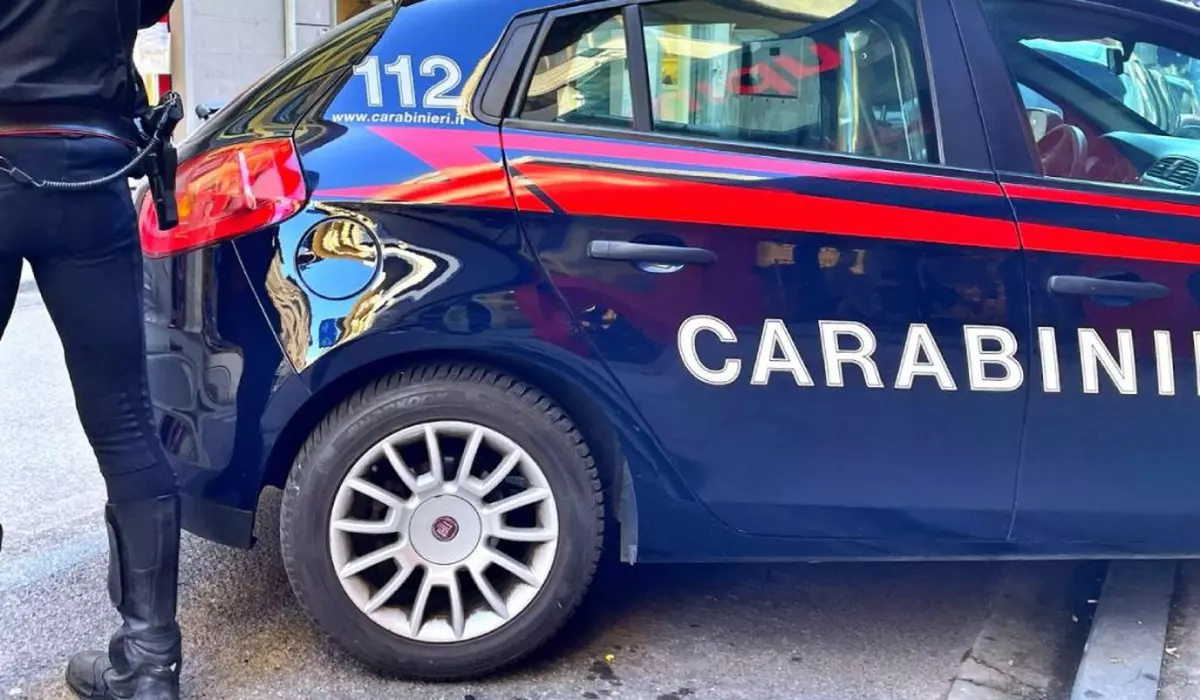Imagine mașine de poliție in Italia, langa ea un polițist in picioare