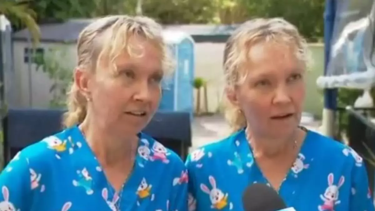 Două surori gemene, blonde, îmbrăcate în trucouri albastre cu imprimeu cu iepurați