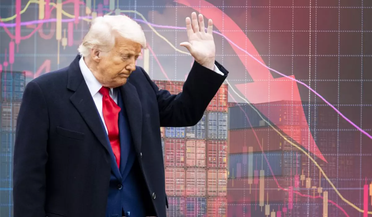 Donald Trump, îmbrăcat într-un costum albastru închis, cu cămașă albă și cravată roșie. Ține o mână ridicată în sus și capul plecat. Pe fundal sunt mai multe containere colorate și un grafic cu o săgeată roșie care arată în jos.