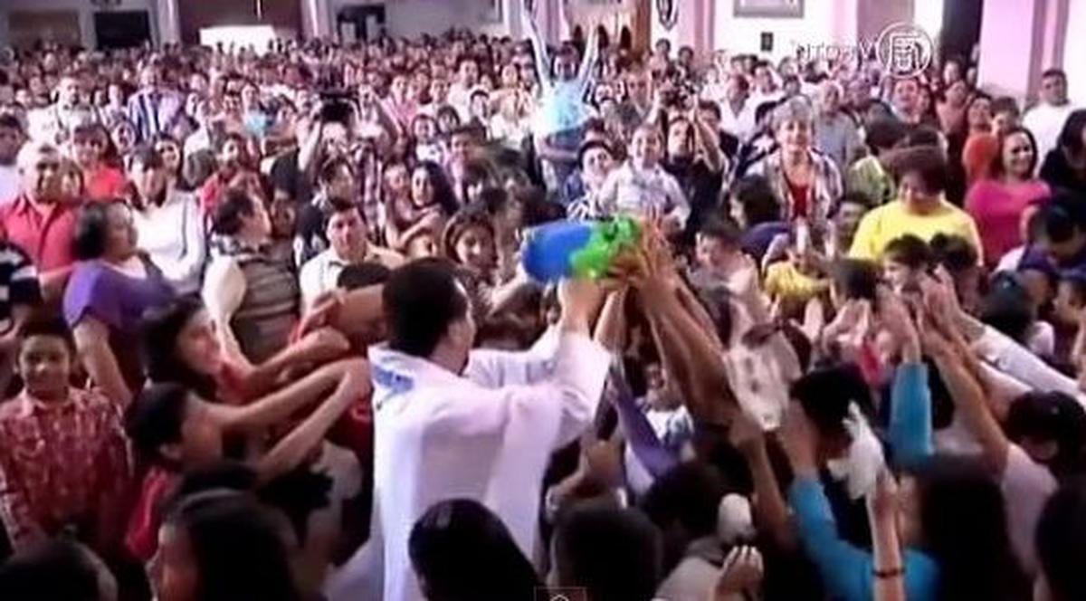 La asta nu te-ai fi gândit! Un preot foloseşte un pistol de jucărie pentru a răspândi apa sfinţită! | VIDEO