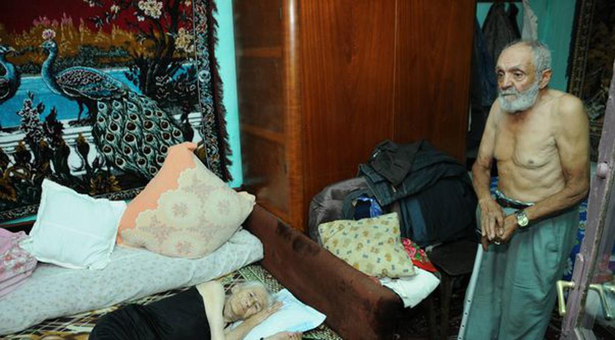 Uitaţi de lume în mijlocul Vasluiului! Doi bătrâni vând râme ca să aibă cu ce trăi | FOTO