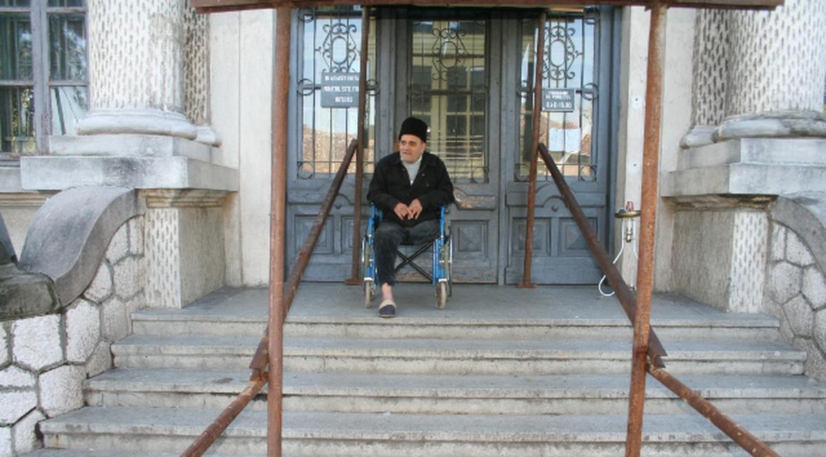 Bătrân în scaun cu rotile, umilit sistematic de instituţiile statului