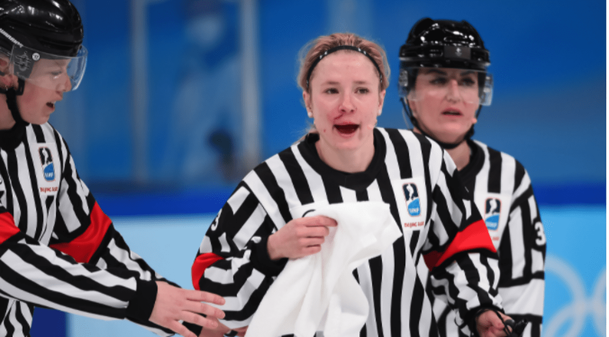 Arbitră plină de sânge, după ce a fost lovită accidental cu crosa, în timpul meciului de hochei Canada - SUA, din turneul olimpic feminin