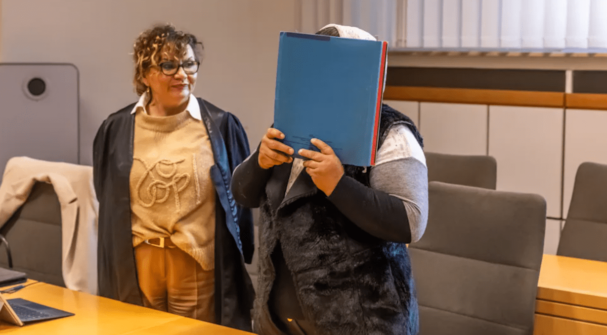 Românca își acoperă chipul cu un dosar.