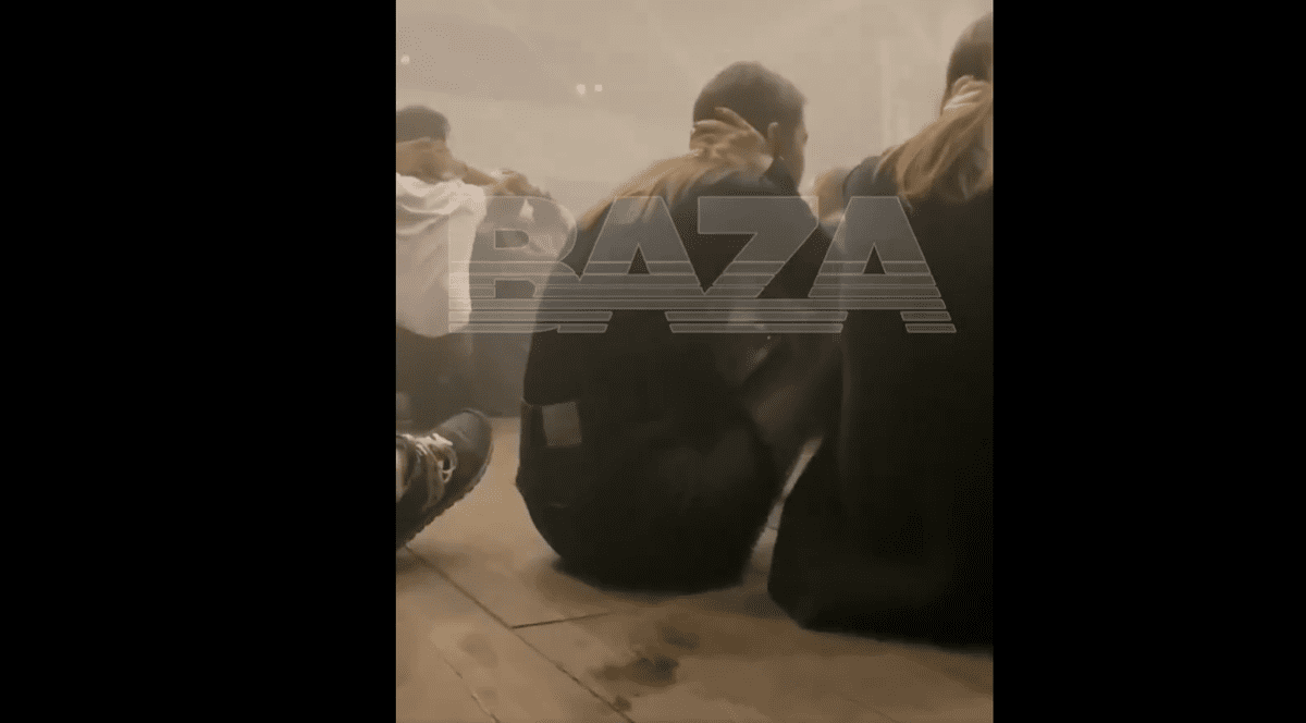 Mai multe persoane stau pe jos