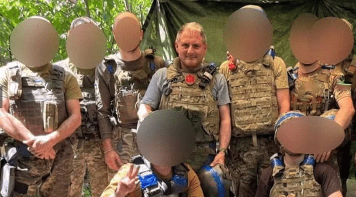 Jack Lopresti, central, fata neblurata, in mijlocul unor luptători din Legiunea Internațională care luptă în Ucraina