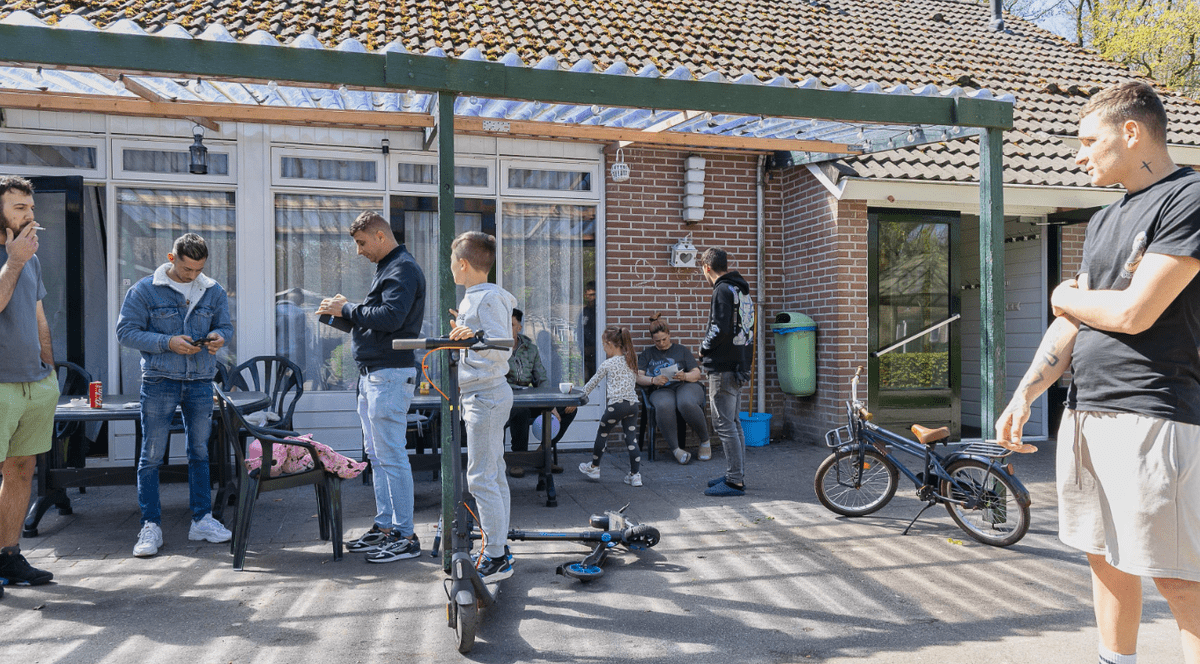 Poză cu mai mulți români și doi copii strânși în fața unei case din parcul olandez Van Harte