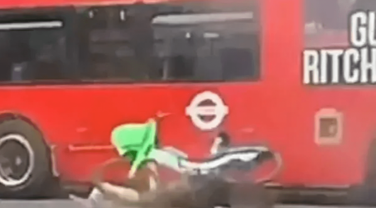 o bicicletă răsturnaată lângă un utobuz rosu, etajat.