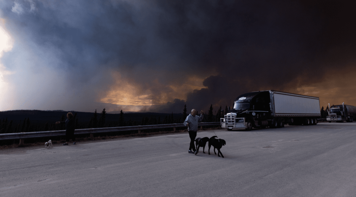 Un fum gros se vede la marginea unui autostrăzi în urma incendiilor majore din Canada