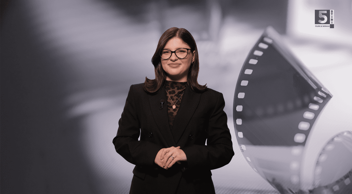 Adelina Duinea, gazda rubricii 5 știri by Libertatea - Filme și seriale, îmbrăcată cu un sacou negru, pe un fundal gri, alb și negru.
