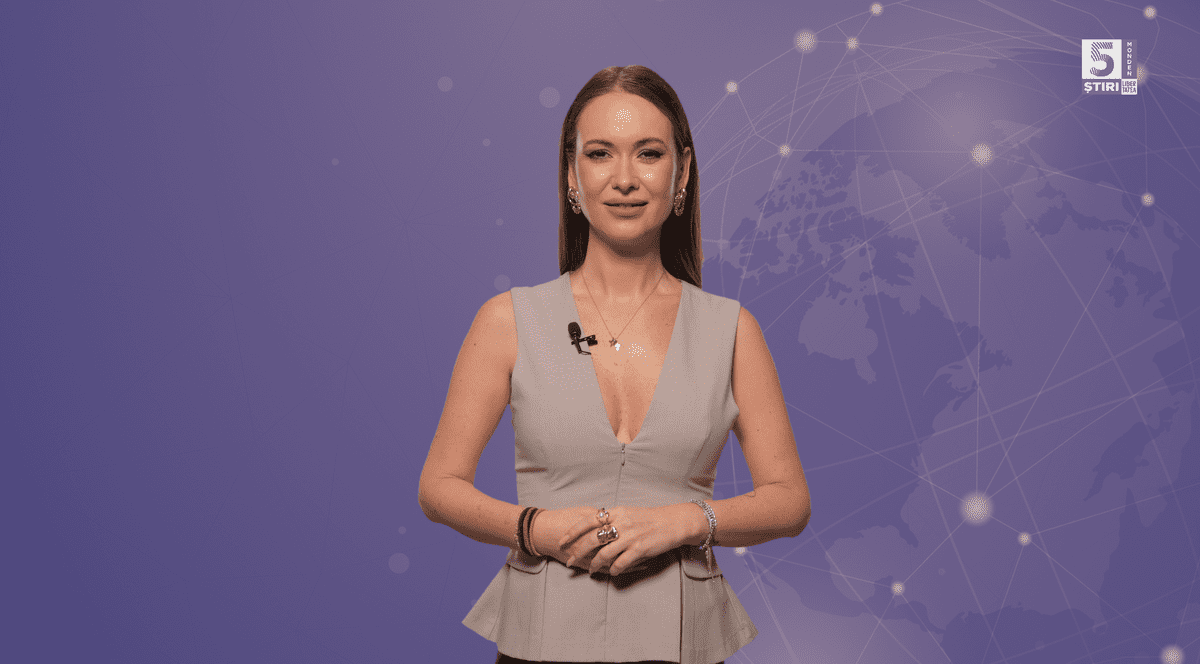Denisa Macovei, gazda rubricii 5 știri by Libertatea - Monden, îmbrăcată într-o bluză crem, pe un fundal mov.