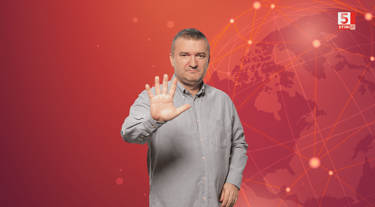 Dorin Chioțea, redactor-șef Libertatea, îmbrăcat cu o cămașă gri, pe un fundal roșu.