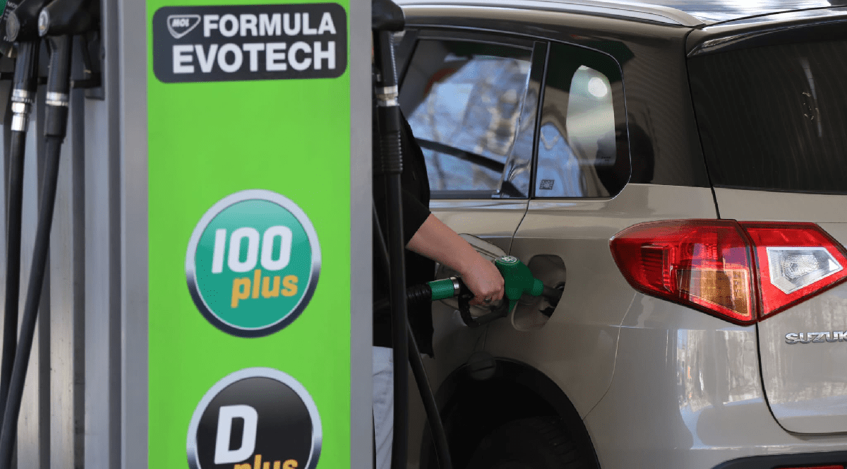 Imaginea surprinde o persoană care alimentează cu carburant un autoturism Suzuki la o stație MOL, evidențiind în prim-plan pompa cu noile sortimente de combustibil „Formula Evotech”.