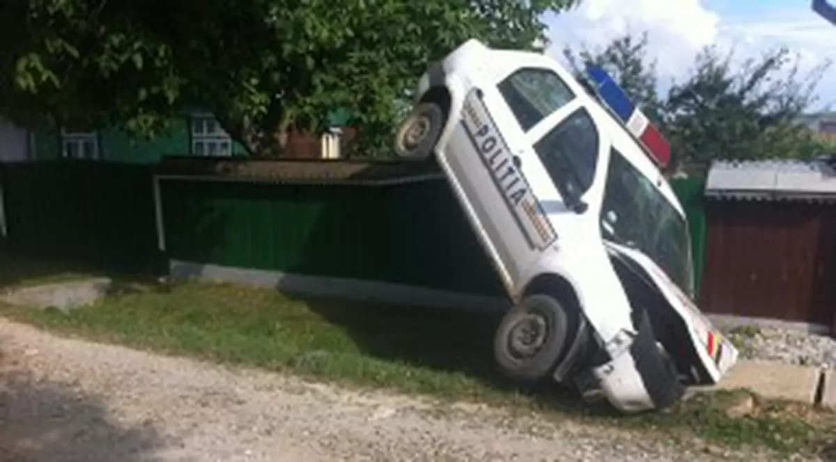 Mașină a poliţiei atîrnată de un gard după o acţiune de urmărire | FOTO