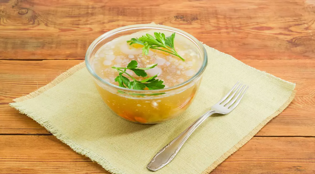 diferenta aspic si piftie- un bol cu piftie asezat pe p masa de lemn