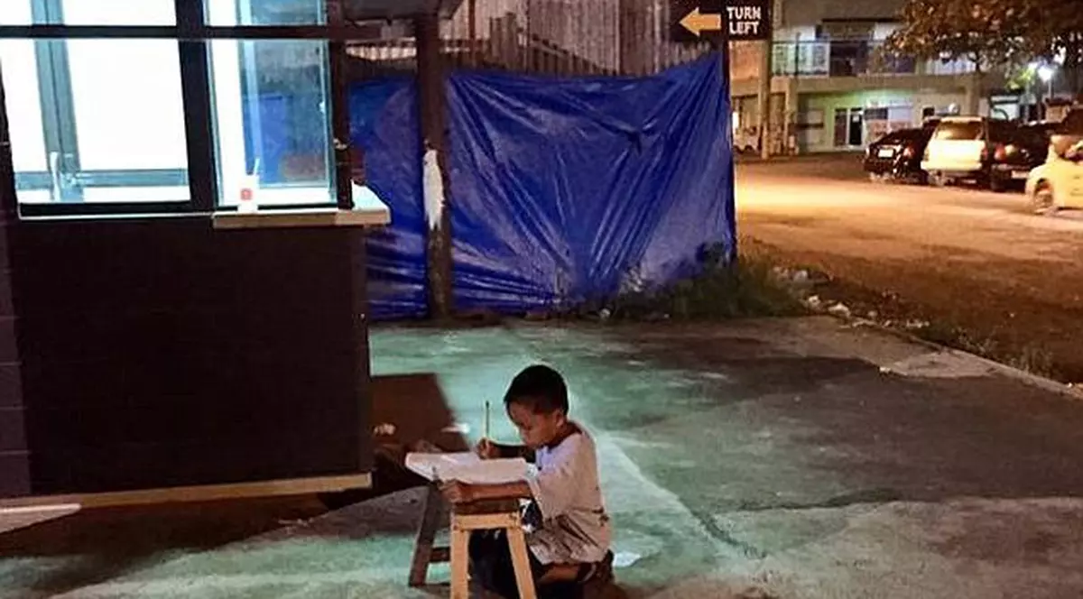 Imagini cutremurătoare! Un copil de 9 ani îşi face temele pe strada, la lumina unui restaurant. Ce s-a întâmplat cu el 