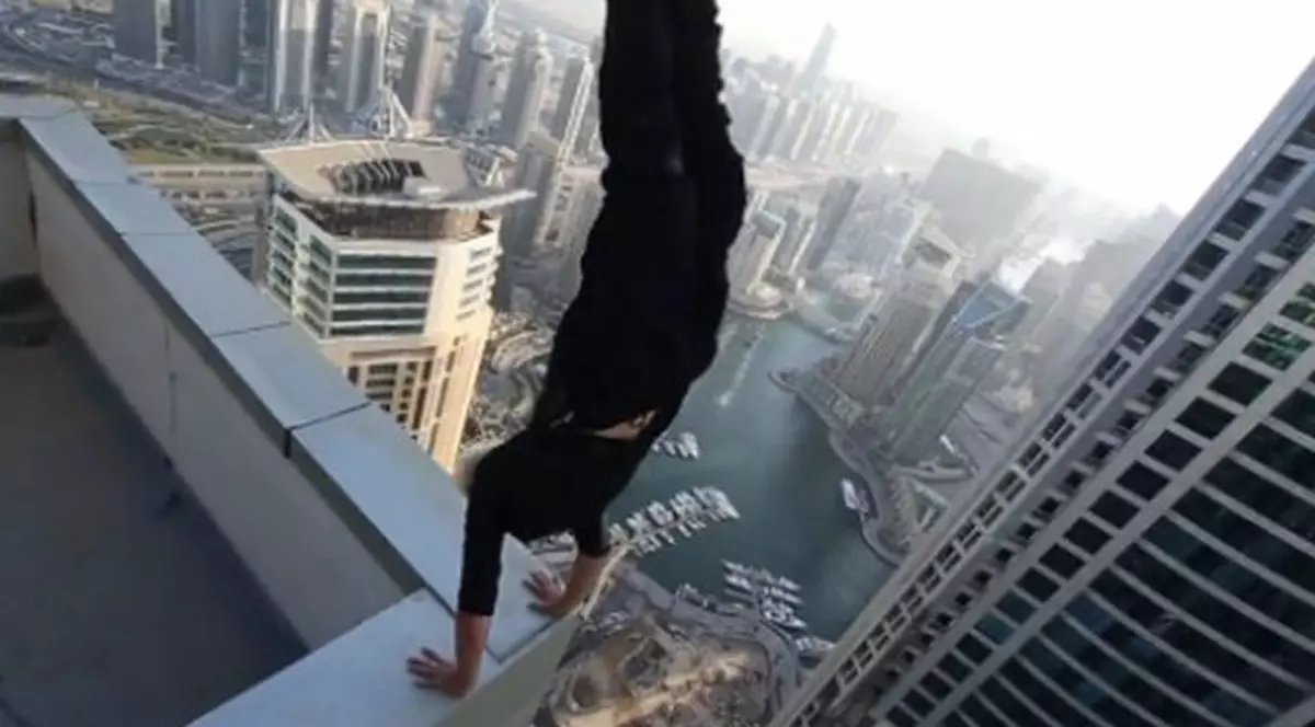 Cât curaj! Exerciţiul de echilibru făcut de un tânăr pe un zgârie nori uimeşte mii de oameni