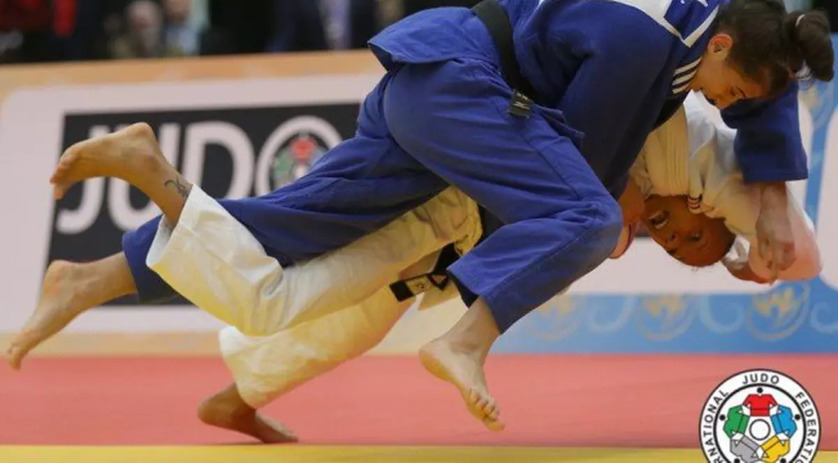 Larisa Florian (în albastru), încearcă să-şi pună adversara la podea.