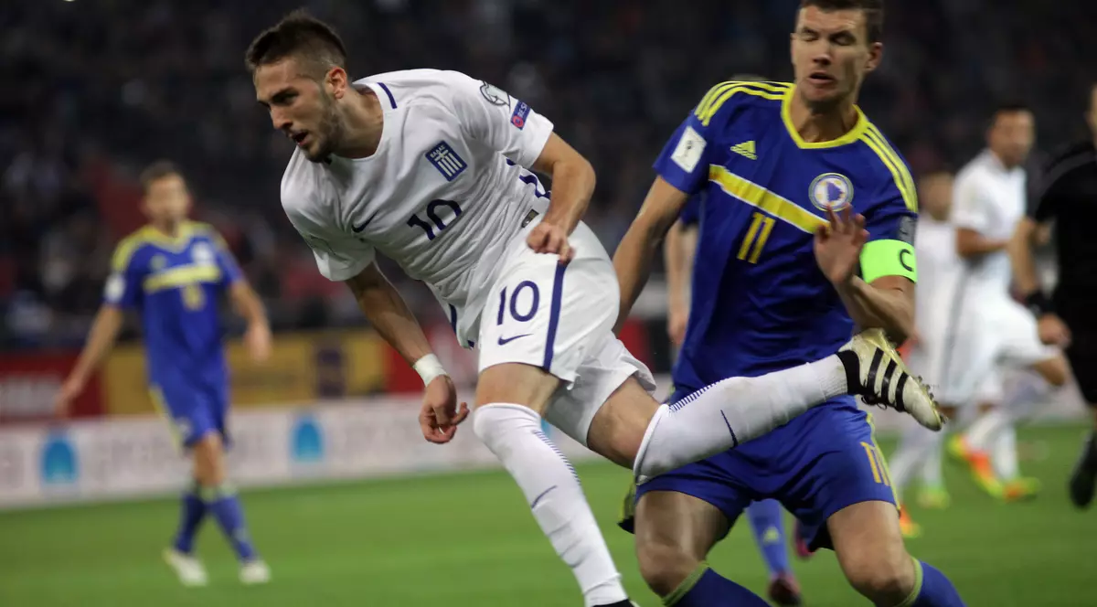 Kostas Fortounis (în alb), în duel cu Edin Dzeko, în timpul meciului Grecia-Bosnia (1-1) disputat duminică, 13 noiembrie, în preliminariile CM 2018. (FOTO: EPA)