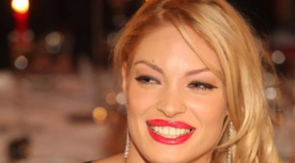 valentina Pelinel, îmbrăcată într-o rochie neagră cu decolteu adânc și zâmbind larg