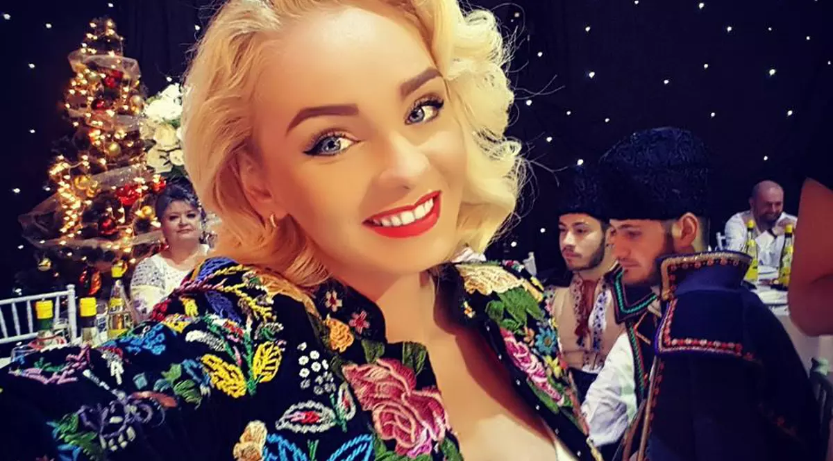 Maria Constantin, îmbrăcată în port tradițional, zâmbește în platoul unei emisiuni de televiziune