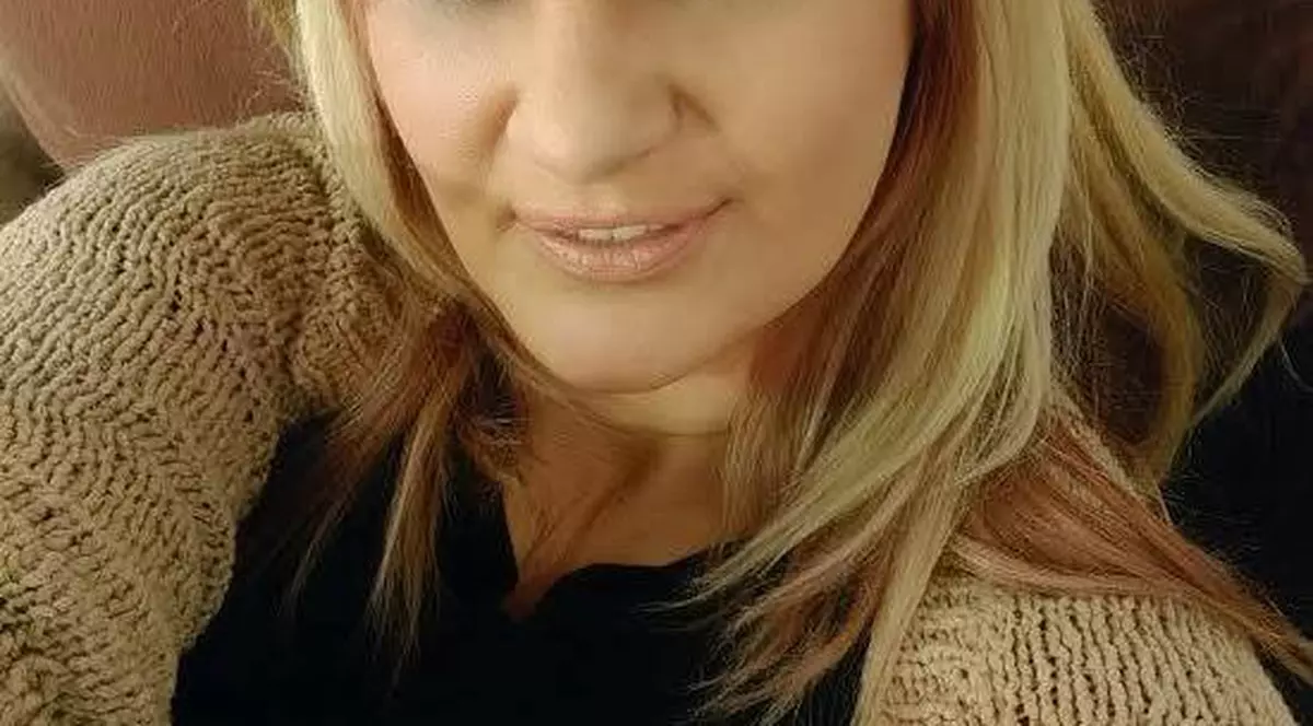 Îmbrăcată într-un pulover negru cu maro, nicola își face un selfie în cameră