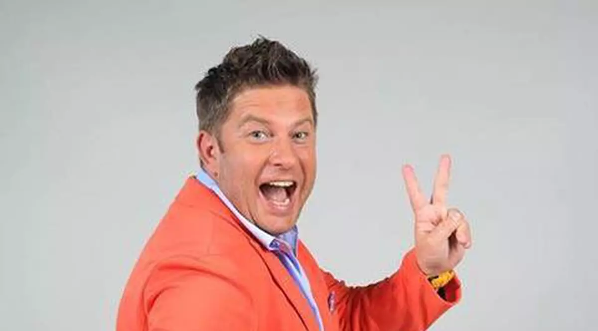 pavel barto;, ]mbr[cat ]ntr-un sacou portocaliu, face semnul victoriei