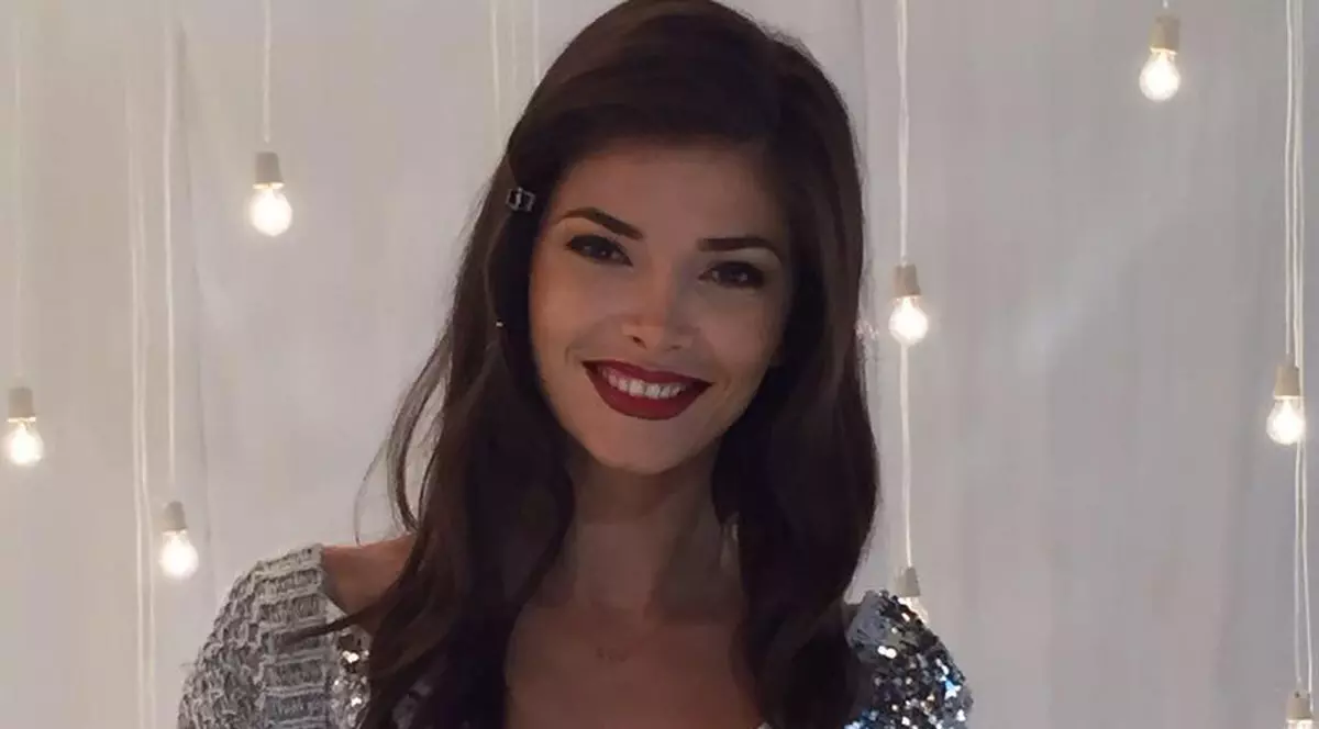Alina Pușcaș zâmbește în timp ce e fotografiată într-un studio