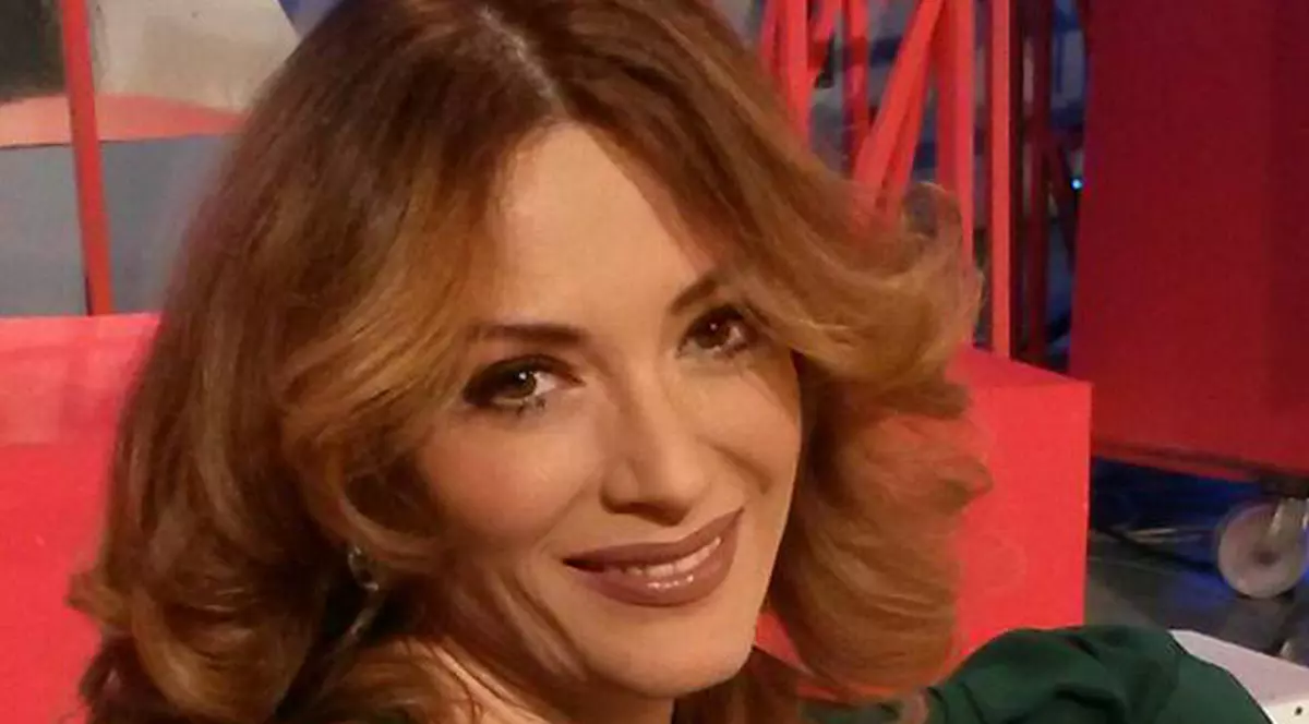 Anca Țurcașiu, îmbrăcată în verde, se relasează pe o canapea