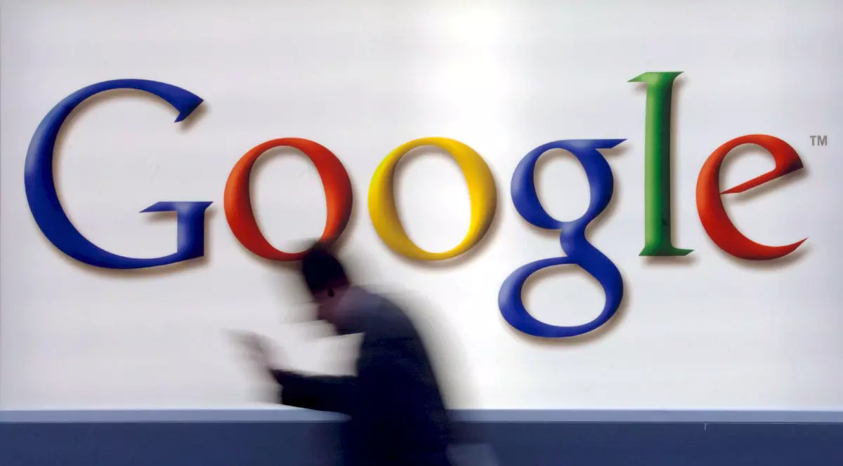 Google, reclamată din nou la Comisia Europeană de rivali online. Logo-ul Google prin fața căruia trece un om