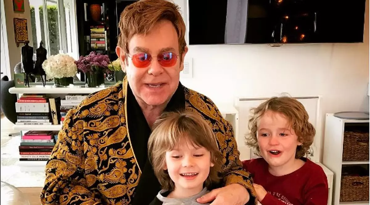 Elton John alături de cei doi copii ai săi și un tort de ciocolată