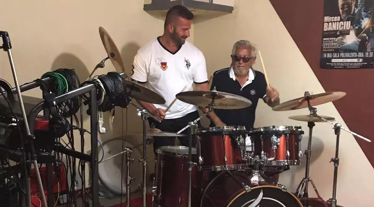 Ovidiu Lipan Țăndărică se antrenează bătând tobele. Prietenul Gabi Toncean, șeful de la fitness, a făcut și el pe bateristul.