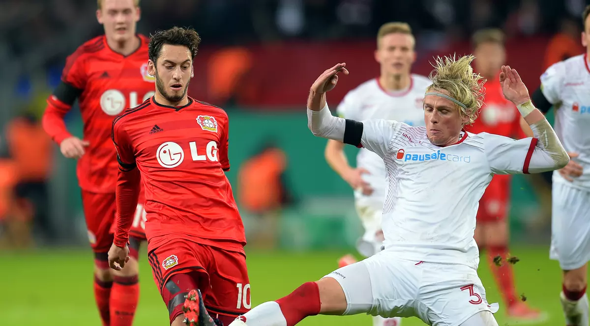 FCSB transferă un fundaș central de la Kaiserslautern. Tim Heubach (dreapta) bagă o alunecare la Hakan Calhanoglu (stânga), într-un meci Kaiserslautern - Bayer Leverkusen din Cupa Germaniei