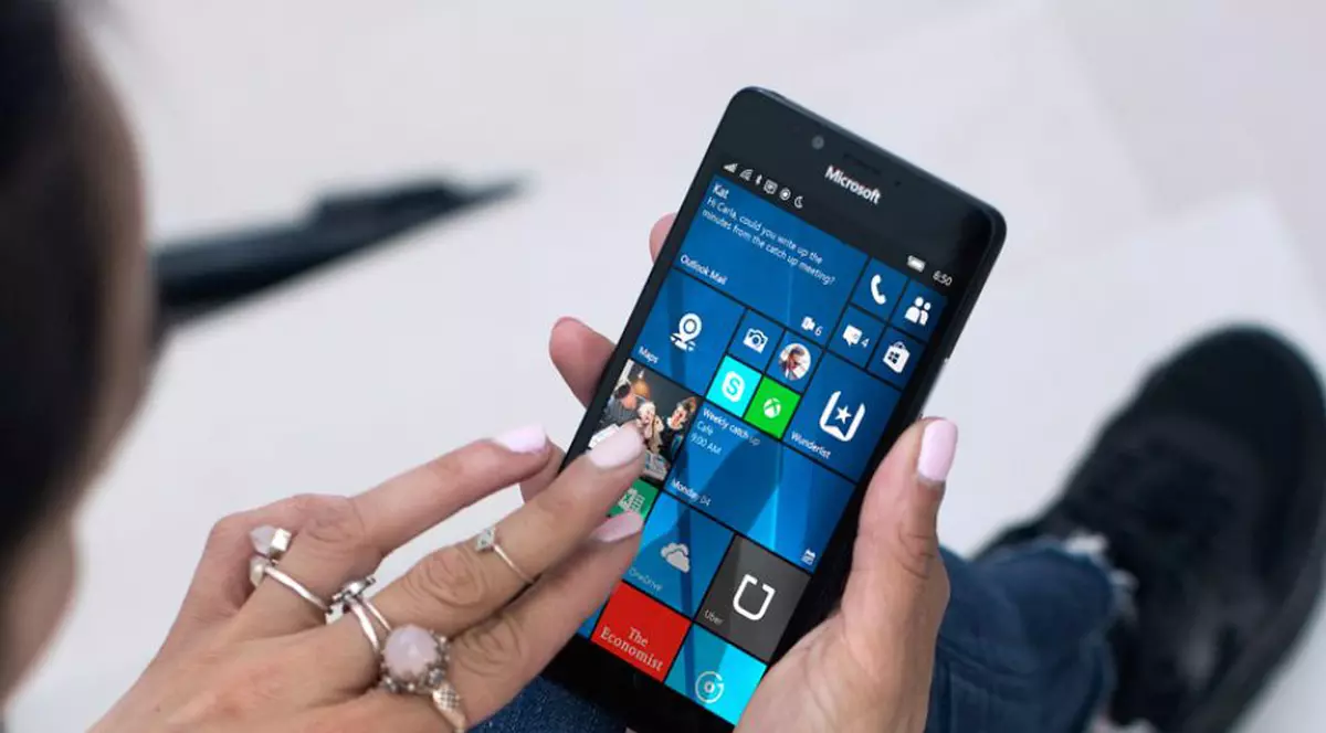 MIcrosoft anunță oficial că Windows Phone a murit. Sistemul de operare nu va mai fi dezvoltat. Tânără care ține un model Lumia 950 în mână